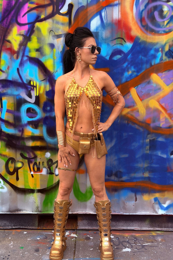 Model draagt de Festival Pailletten top Golden Hour in goud, gecombineerd met gouden statement boots en festival accessoires.