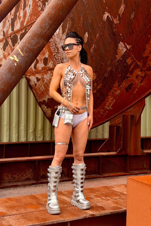 Vrouw draagt de zilveren Silver Eclipse body chain top van TOUTESTBELLE met zilveren festival boots en festival accessoires.