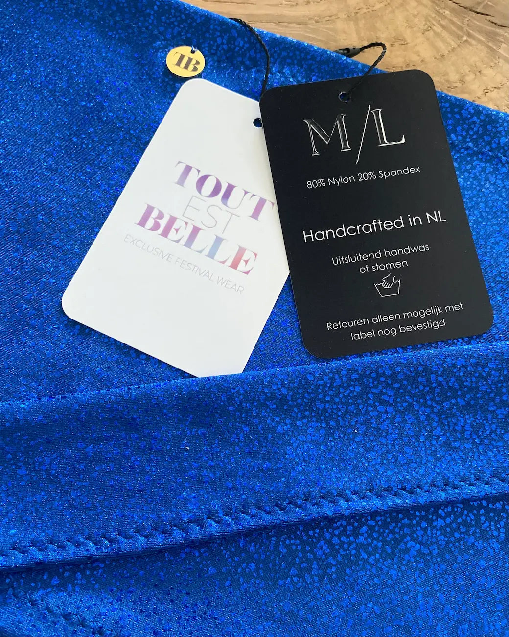 Close-up van het designproces van TOUTESTBELLE: handgemaakte festival wear met premium stretch stof, labels en afwerking, ontworpen in Nederland.